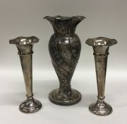 A silver embossed spill vase together with a pair
