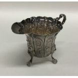 An Irish silver cream jug embossed with flowers an