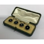 A boxed set of gold and onyx cufflinks mounted wit