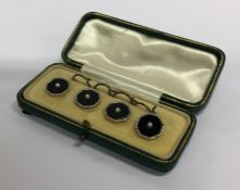 A boxed set of gold and onyx cufflinks mounted wit