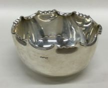 A circular silver sugar bowl with crimped rim. She