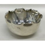 A circular silver sugar bowl with crimped rim. She