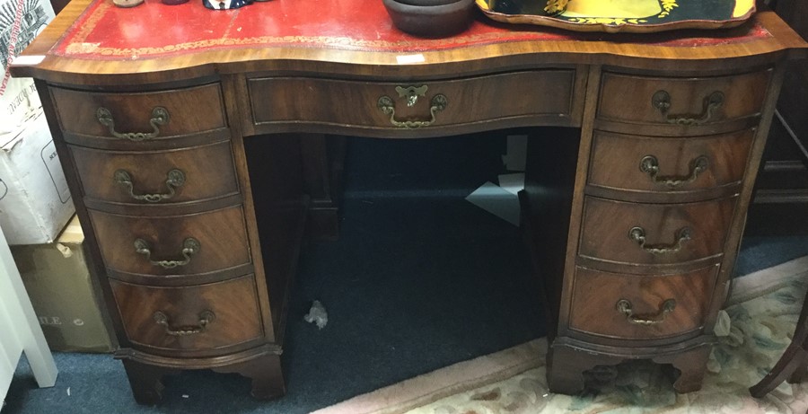 A mahogany shaped front twin pedestal desk.