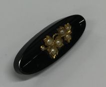 An onyx, pearl and gold boat shaped bar brooch wit