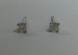 A pair of small diamond ear studs in claw mount. E