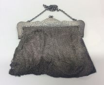 A silver mesh purse on suspension chain. Approx. 3