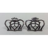 A pair of silver menu holders with shield decorati