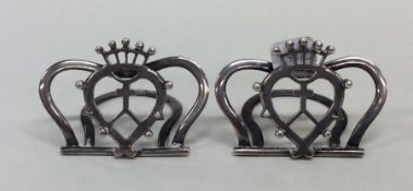 A pair of silver menu holders with shield decorati