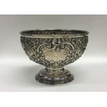 A silver embossed rose bowl decorated with flowers