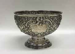 A silver embossed rose bowl decorated with flowers