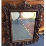 A Continental oak framed bevelled mirror.