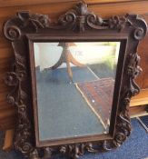 A Continental oak framed bevelled mirror.