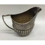 A silver half fluted helmet shaped cream jug. Shef