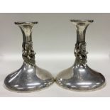 A pair of stylish silver candlesticks decorated wi