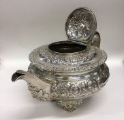 A good Georgian embossed silver teapot with leaf c