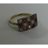 A ruby and diamond chequerboard ring in gold and p