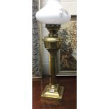 A brass Corinthian column lamp with glass shade.