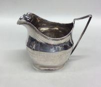 A Georgian bright cut silver cream jug with reeded