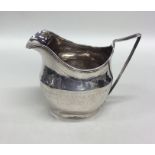 A Georgian bright cut silver cream jug with reeded