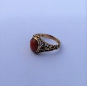 A 9 carat single stone ring inset with coral. Appr