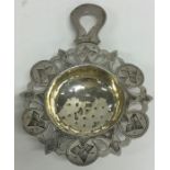 A Russian silver pierced tea strainer decorated wi