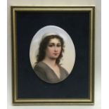 An oval porcelain miniature of a lady with wavy ha