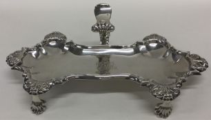 A heavy cast silver snuffer tray with shell border