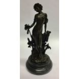 A bronzed figure of a stylish lady on circular ped