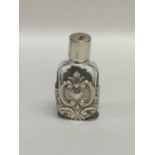 A small silver embossed scent bottle, decorated wi