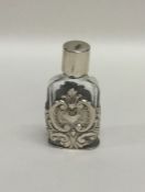 A small silver embossed scent bottle, decorated wi