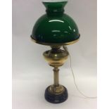 A brass mounted oil lamp with green shade. Est. £3