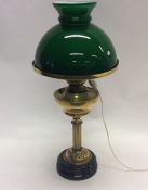 A brass mounted oil lamp with green shade. Est. £3