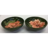 MOORCROFT: Two shallow dishes decorated with flowe