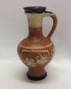 A slipware oviform jug decorated with flowers, the