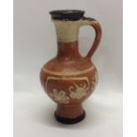 A slipware oviform jug decorated with flowers, the