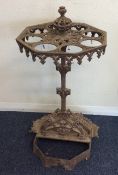 A cast iron umbrella stand decorated with scrolls.