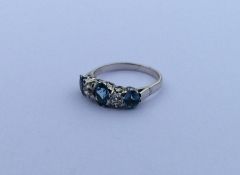 An aquamarine and diamond five stone ring in white