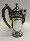 A heavy silver water jug with panelled sides. Shef