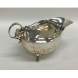 A silver sauce boat with card cut rim and scroll f