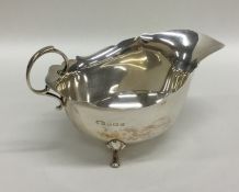 A silver sauce boat with card cut rim and scroll f