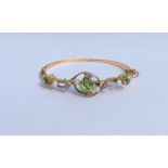 A large peridot and pearl hinged bangle with swirl