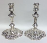 A pair of heavy cast George II silver candlesticks