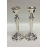 A pair of tapering silver candlesticks with bead d