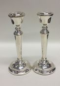 A pair of tapering silver candlesticks with bead d