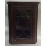 An Antique oak corner cupboard with panelled glass