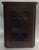 An Antique oak corner cupboard with panelled glass