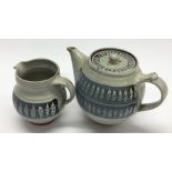 MARIANNE DE TREY: A pottery teapot and matching cr