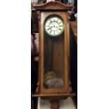 A large mahogany wall clock with shaped top and wh