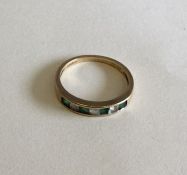 An emerald and gold half eternity ring. Approx. 2.