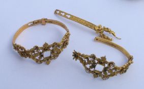 Two gilt bangles engraved with flowers. Approx. 28